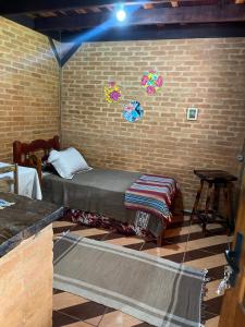 a room with a bed and a brick wall at Chale Nha Chica in Alagoa +18 photos