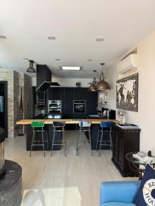 a kitchen with black cabinets and bar stools at Villalino Tre Palme, Pool, 2 Schlafzimmer, 2 Bäder, Pool, Terrasse, Outdoor Fitness in Alassio +25 photos