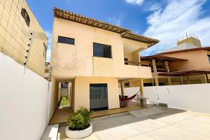 ein Haus mit einem weißen Zaun davor in der Unterkunft Casa 5/4 Atalaia a 200m da Passarela do Caranguejo in Santa Maria