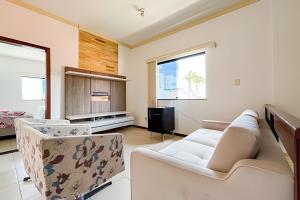 ein Wohnzimmer mit Sofa und Fernseher in der Unterkunft Casa 5/4 Atalaia a 200m da Passarela do Caranguejo in Santa Maria