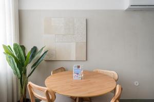 a wooden table in a room with chairs and a painting at GuestReady - Exquisite stay in Matosinhos in Matosinhos +19 photos