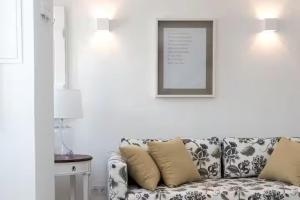 a living room with a couch and a picture on the wall at Segredos da Muralha in Óbidos