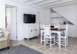 a living room with a table and chairs and a tv at Segredos da Muralha in Óbidos +76 photos