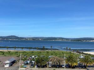 a view of a beach with palm trees and a parking lot at Apartamento centro de Sada in Sada