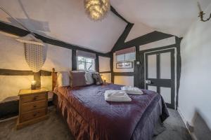 a bedroom with a bed with a purple comforter at The Boars Head Pub in Bishops Castle