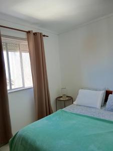 a bedroom with a bed and a window at Casa Das Riscas Verdes in Gafanha da Encarnação