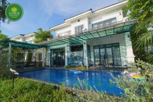 a house with a swimming pool in front of it at Lotus Hotel Vuon Vua Phu Tho in Phú Thọ
