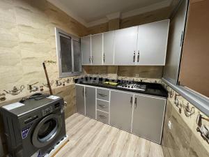a small kitchen with a washing machine in it at beach apartment in Fnidek