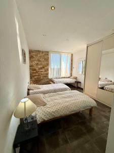 een slaapkamer met twee bedden en een bakstenen muur bij Cortijo Maya, maison troglodyte pour 10 personnes in Alhama de Almería