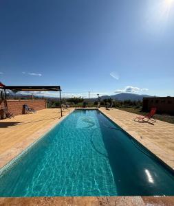 een zwembad met blauw water en bergen op de achtergrond bij Cortijo Maya, maison troglodyte pour 10 personnes in Alhama de Almería