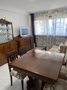 Una sala de estar con una mesa y sillas de madera. en Playa Panxón Mar, en Nigrán