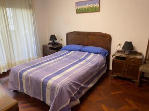 1 dormitorio con 1 cama con manta de rayas azul y blanco en Playa Panxón Mar, en Nigrán