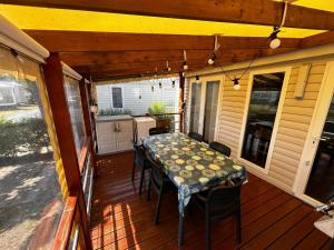 a patio with a table and chairs on a deck at Détente en 4 étoiles jusque 6 personnes, selon la dispo in Saint-Jean-de-Monts