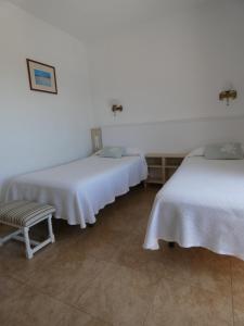 A bed or beds in a room at Hostal Port Fornells