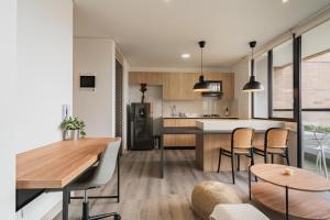 a kitchen and living room with a table and chairs at Grand By Jalo in Medellín