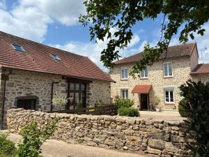 a stone house with a stone wall in front of it at Gîte au Bon Accueil Therence in Sainte-Thérence