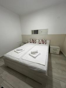 a white bedroom with a large white bed with pillows at Apartment DN 12 in Baška