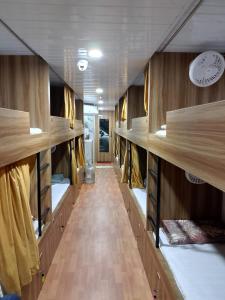 a room with wooden shelves and a long hallway at Sun Shine AC Dormitory in Mumbai +43 photos