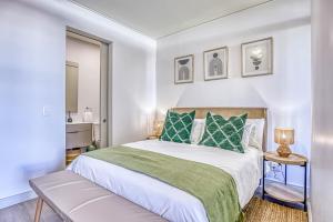 a bedroom with a large bed with green pillows at Urban Oasis at One Rosebank in Johannesburg