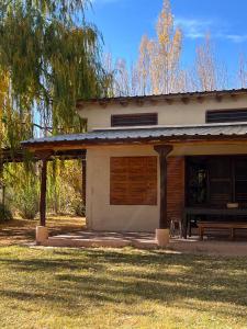 a house with a bench in front of it at La Loica in Barreal