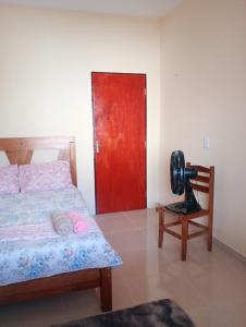 a bedroom with a bed and a red door at Hosting in Camocim in Camocim +4 photos