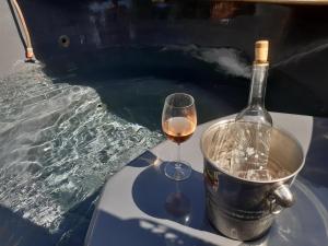 a bottle and a glass of wine on a table in a swimming pool at Pomezní bouda in Horní Malá Úpa