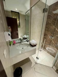 a bathroom with a sink and a shower at Aurum Luxury Apartments Gulberg Lahore - LMY in Lahore
