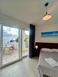 una camera da letto con un letto e una porta scorrevole in vetro di Rooms del Moro a Patù