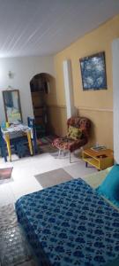 a bedroom with a bed and a chair and a table at GRUTA da Praia 2 in Saquarema