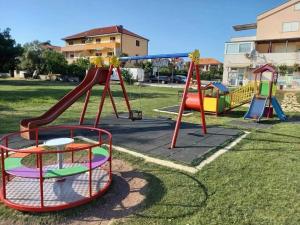 a playground with two slides and a swing set at Mobile home 4US in Privlaka