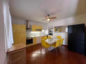 a kitchen and dining room with a table and yellow chairs at Villa Rafaela Umag in Umag