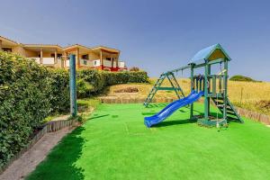 a playground with a slide in a yard at Appartamento Favoloso in Tergu