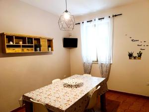 a dining room with a table and a window at Jole Guesthouse in Mazzarino