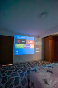 een slaapkamer met een groot scherm aan de muur bij Belén Vibe in Medellín