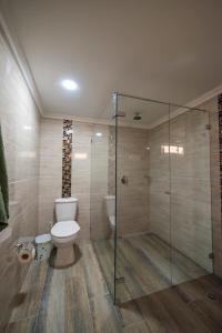een badkamer met toilet en glazen douche bij Belén Vibe in Medellín