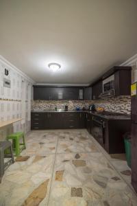 een keuken met zwarte kasten en een tegelvloer bij Belén Vibe in Medellín