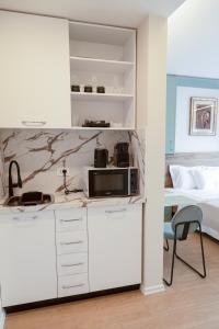 - une cuisine équipée d'un four micro-ondes et un lit dans une chambre dans l'établissement BnB Tirana Centro Balcony, à Tirana