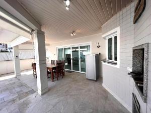 a kitchen and dining room with a table and refrigerator at Casa Condomínio Fechado Hanga Roa Bertioga in Bertioga +48 photos