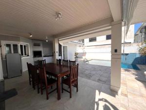 a dining room and kitchen with a table and chairs at Casa Condomínio Fechado Hanga Roa Bertioga in Bertioga