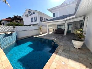 a swimming pool in the backyard of a house at Casa Condomínio Fechado Hanga Roa Bertioga in Bertioga