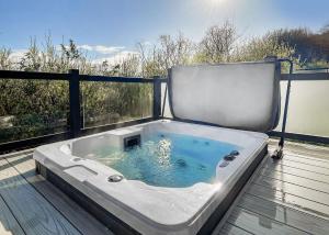 a jacuzzi tub sitting on a deck at Cheddar Woods Resort And Spa in Cheddar