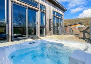 a hot tub in front of a house at Cheddar Woods Resort And Spa in Cheddar