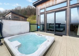 a jacuzzi tub on the deck of a house at Cheddar Woods Resort And Spa in Cheddar +37 photos