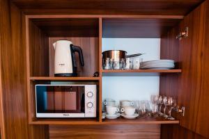 a cupboard with a microwave and plates and glasses at Casa Petra in Sibiu