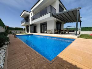 a house with a swimming pool in front of a house at Villa Keyif in Seferihisar