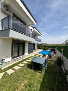 a house with a backyard with a swimming pool at Villa Keyif in Seferihisar