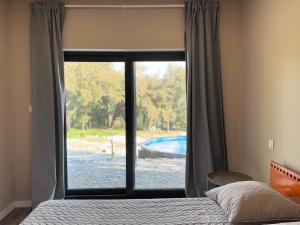 ein Schlafzimmer mit einem Fenster mit Blick auf einen Pool in der Unterkunft Casa do Esquilo in Cabeceiras de Basto + 23 Fotos