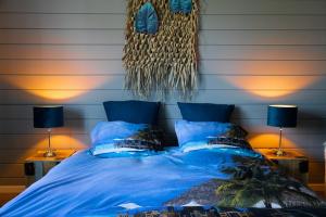 a bedroom with a blue bed with two lamps at Stijl en kleur in Diest