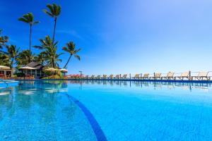 una gran piscina con palmeras y un puente en Armação Resort Porto de Galinhas, en Porto de Galinhas