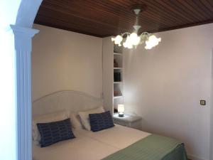 a bedroom with a bed and a chandelier at O lar da praia in Corcubión